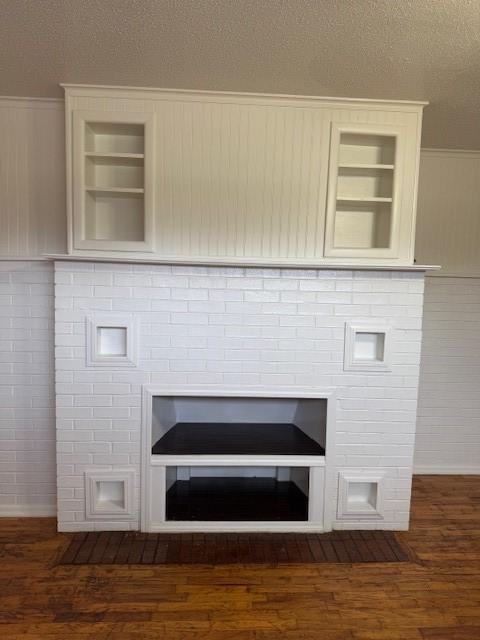 room details featuring built in features, hardwood / wood-style floors, and a textured ceiling