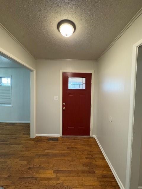 foyer entrance featuring crown molding, dark wood-type flooring, and a textured ceiling