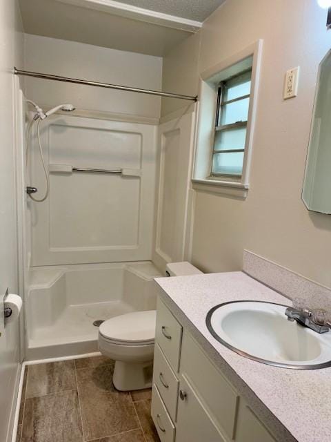 bathroom with tile patterned flooring, vanity, toilet, and walk in shower