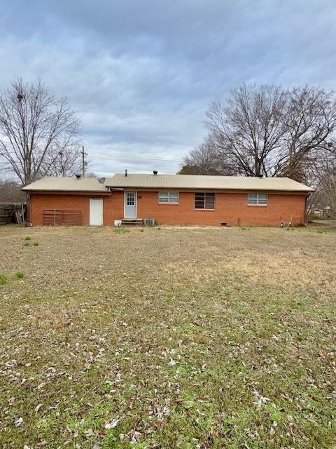 rear view of property with a lawn