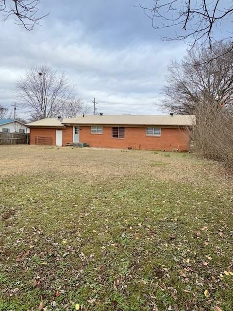 rear view of property featuring a lawn