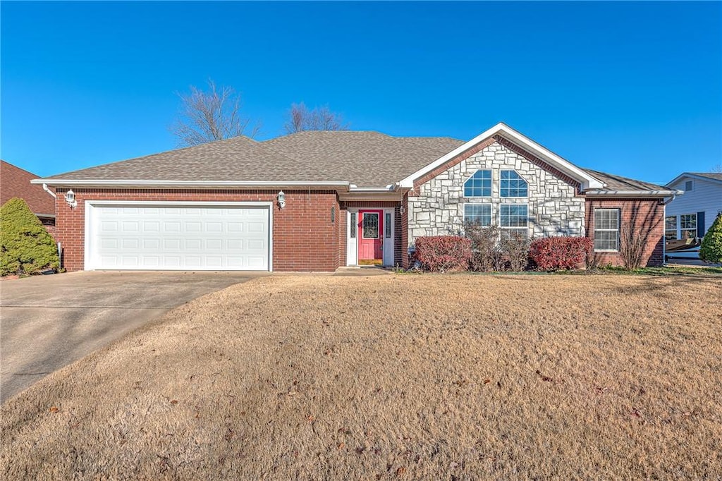 ranch-style home with a garage and a front lawn