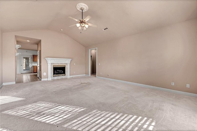 unfurnished living room with light carpet, vaulted ceiling, and ceiling fan