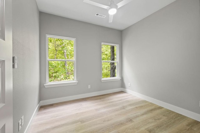 empty room with ceiling fan and light hardwood / wood-style floors