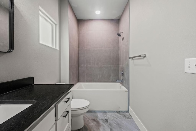 full bathroom featuring vanity, tiled shower / bath combo, and toilet