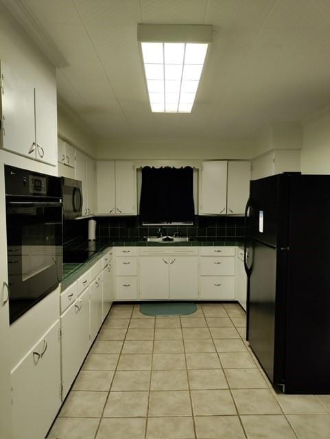 kitchen featuring black appliances, white cabinets, and backsplash