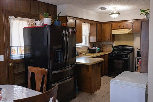 kitchen with black appliances, sink, kitchen peninsula, and a textured ceiling