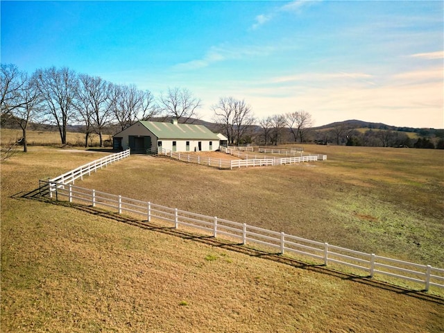 view of yard featuring a mountain view, a rural view, and an outdoor structure