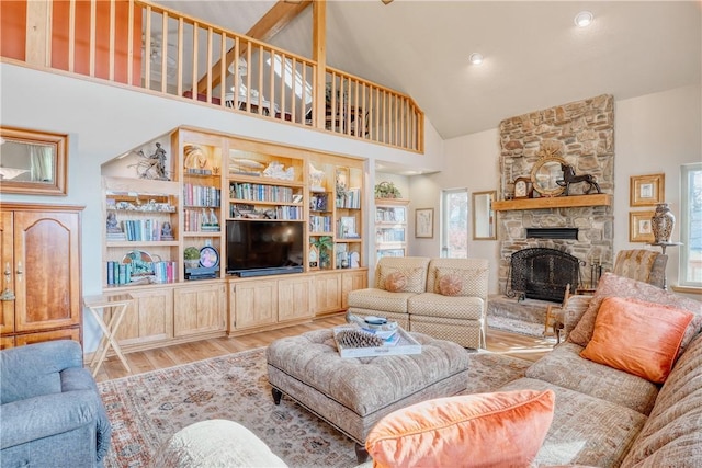 living room featuring a fireplace, a towering ceiling, and wood-type flooring