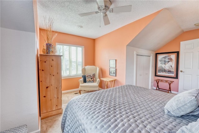 carpeted bedroom featuring a textured ceiling, ceiling fan, a closet, and vaulted ceiling