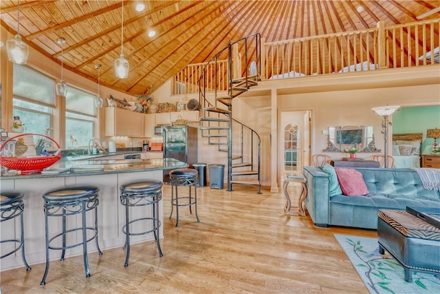 kitchen with decorative light fixtures, stainless steel refrigerator, wood ceiling, and high vaulted ceiling