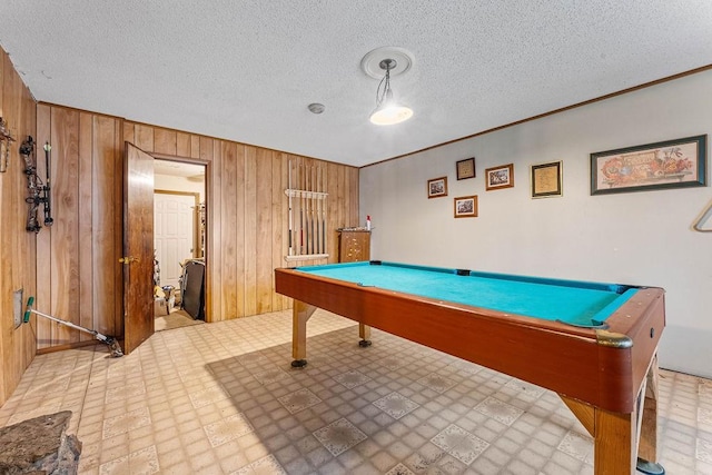 playroom featuring wood walls, a textured ceiling, and pool table