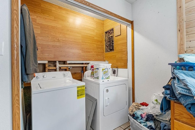 washroom featuring wooden walls and washer and dryer