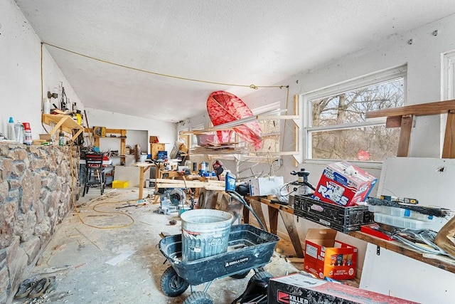 misc room featuring a textured ceiling, a workshop area, and lofted ceiling