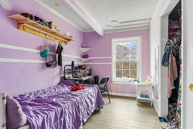 bedroom with light wood-type flooring, a textured ceiling, and crown molding