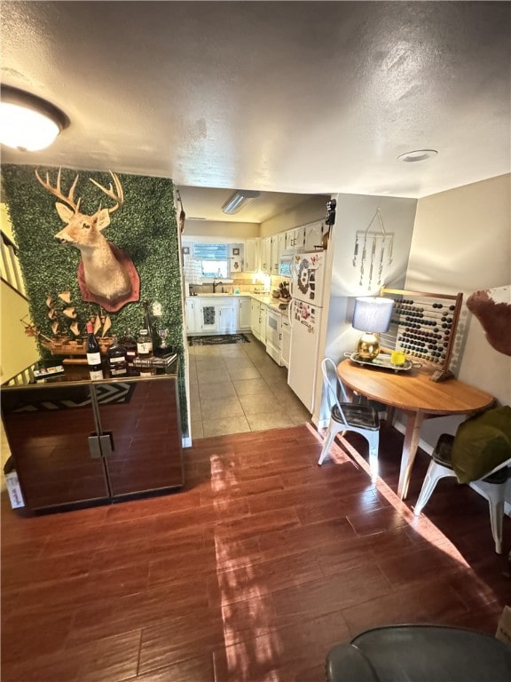 kitchen with white cabinets, white range, sink, and hardwood / wood-style flooring