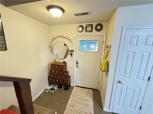 doorway to outside with dark tile patterned floors