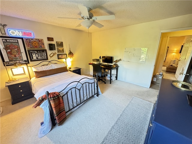 carpeted bedroom with ceiling fan and a textured ceiling