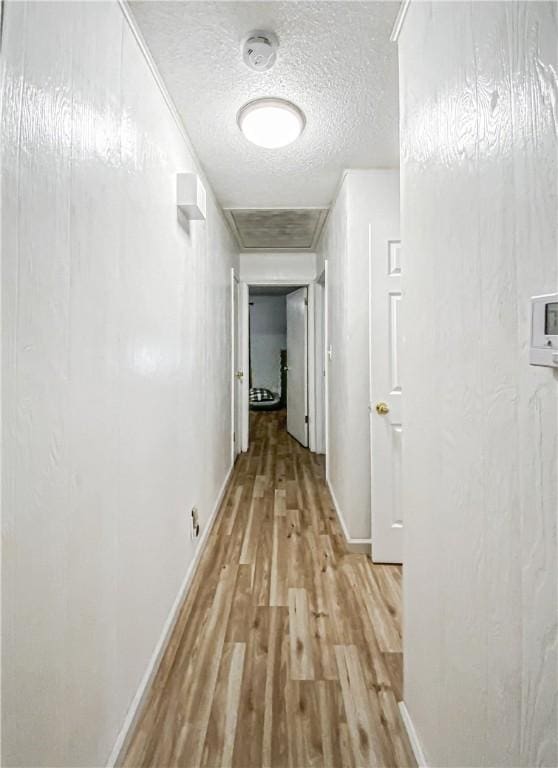 hallway featuring a textured ceiling and light wood-type flooring