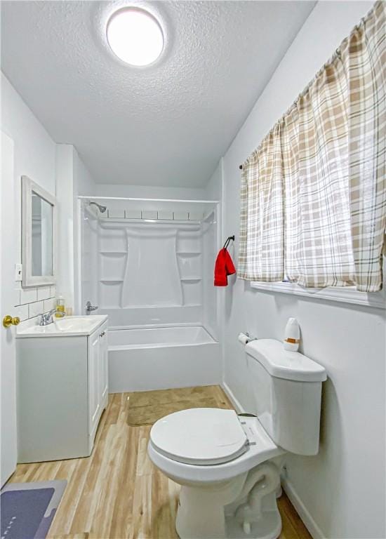 full bathroom with hardwood / wood-style floors, a textured ceiling, toilet, shower / tub combination, and vanity