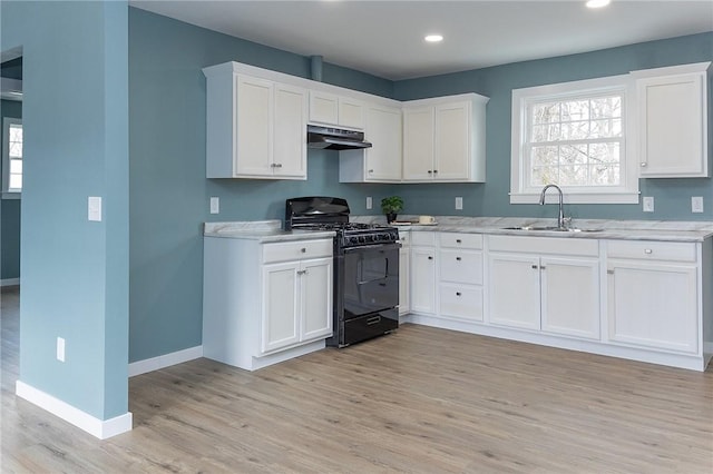 kitchen featuring black range with gas cooktop, white cabinetry, sink, light stone countertops, and light hardwood / wood-style flooring