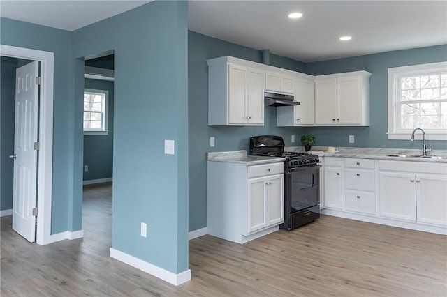 kitchen featuring gas stove, sink, a wealth of natural light, and white cabinets