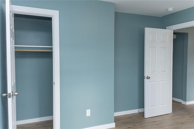 unfurnished bedroom with wood-type flooring and a closet