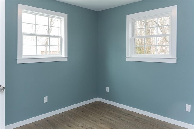 spare room with a healthy amount of sunlight and dark hardwood / wood-style flooring