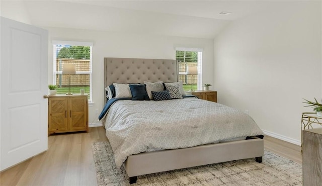 bedroom with lofted ceiling and light wood-type flooring