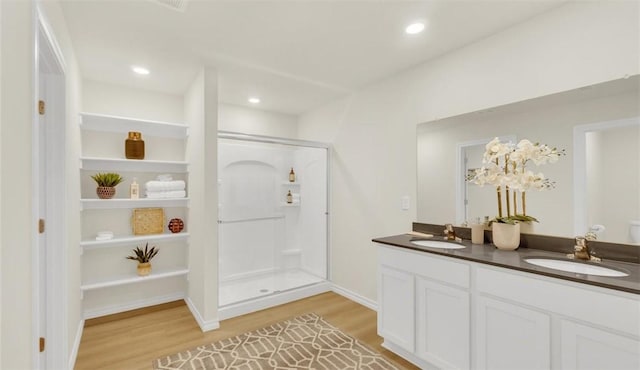 bathroom with wood-type flooring, vanity, and a shower with shower door