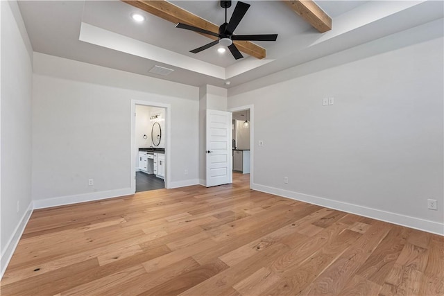 unfurnished bedroom featuring connected bathroom, ceiling fan, beamed ceiling, and light wood-type flooring