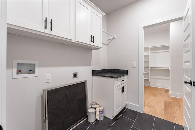 laundry room with cabinets, washer hookup, dark tile patterned floors, hookup for an electric dryer, and heating unit