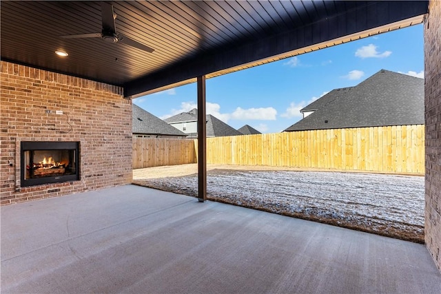 view of patio with an outdoor brick fireplace and ceiling fan