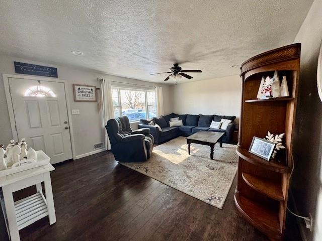 living room featuring a textured ceiling, dark hardwood / wood-style floors, and ceiling fan