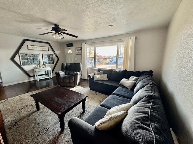 living room with hardwood / wood-style floors, a textured ceiling, and ceiling fan