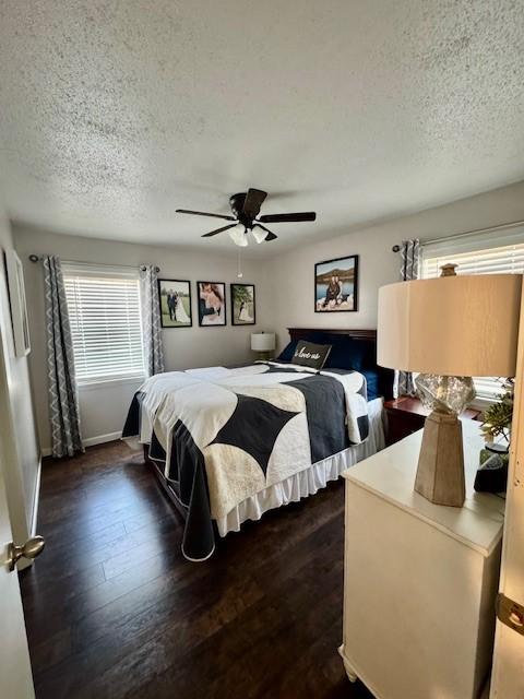 bedroom with ceiling fan, dark hardwood / wood-style floors, and a textured ceiling