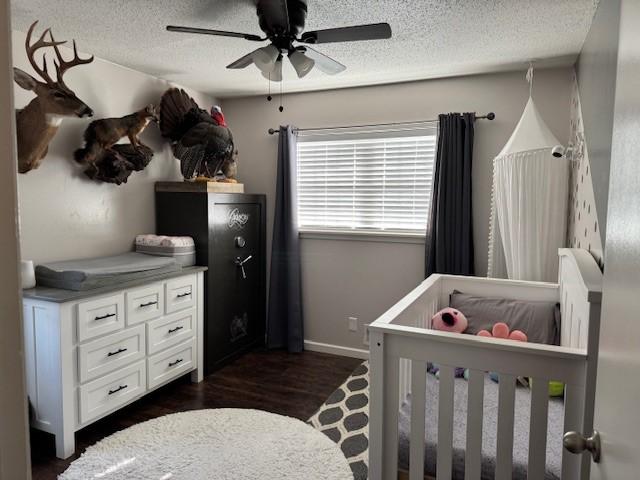 bedroom featuring ceiling fan, dark hardwood / wood-style flooring, and a textured ceiling