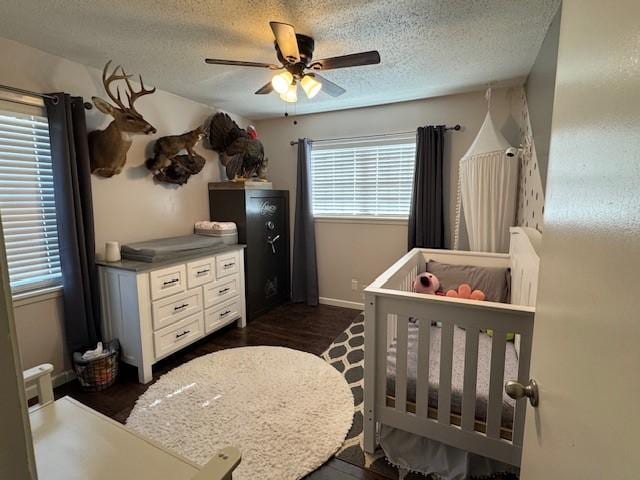 bedroom with ceiling fan, dark hardwood / wood-style flooring, and a textured ceiling