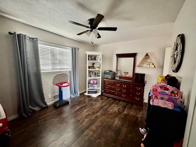 bedroom featuring a textured ceiling, ceiling fan, and dark hardwood / wood-style floors