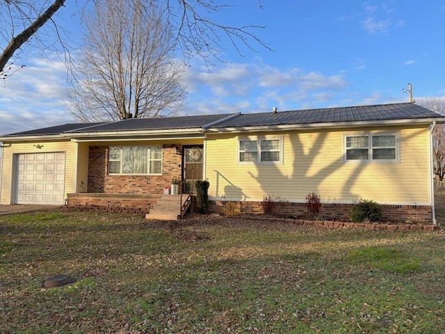 view of front of property with metal roof, a garage, and a front yard