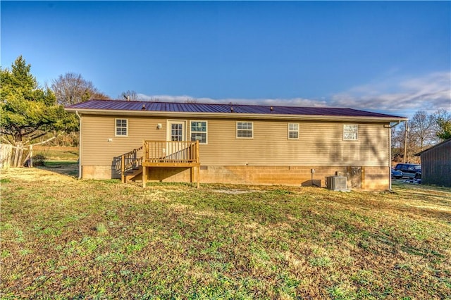 rear view of house featuring a lawn and central AC