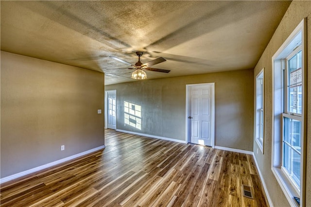 unfurnished room with wood-type flooring, a textured ceiling, and ceiling fan