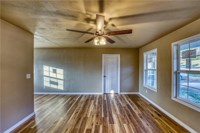 spare room with ceiling fan, hardwood / wood-style floors, and a textured ceiling