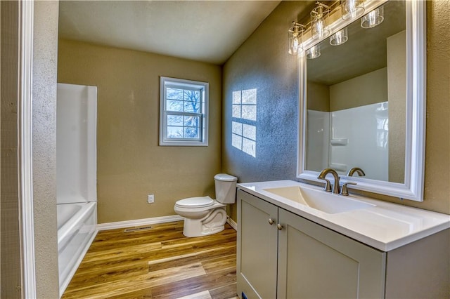 full bathroom featuring hardwood / wood-style floors, vanity, toilet, and washtub / shower combination