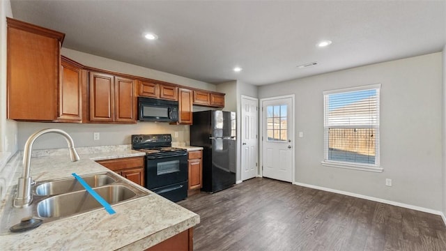 kitchen featuring sink, dark hardwood / wood-style floors, and black appliances