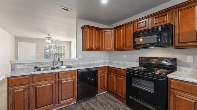 kitchen with ceiling fan, sink, light stone counters, dark hardwood / wood-style flooring, and black appliances