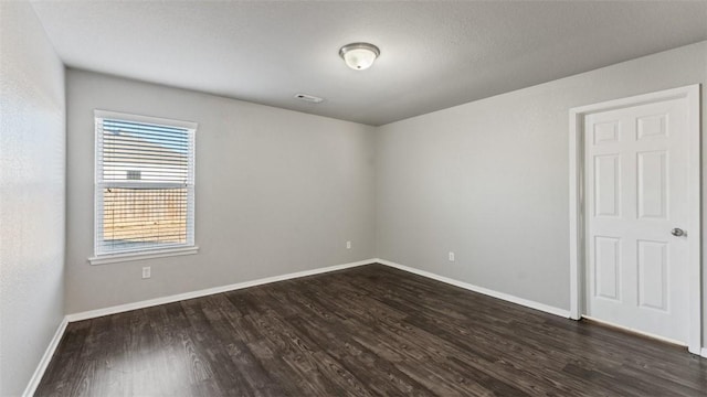 spare room with dark wood-type flooring