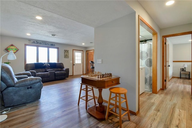 living room featuring a textured ceiling and light hardwood / wood-style floors