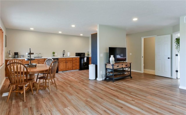 dining space with light wood-type flooring and sink