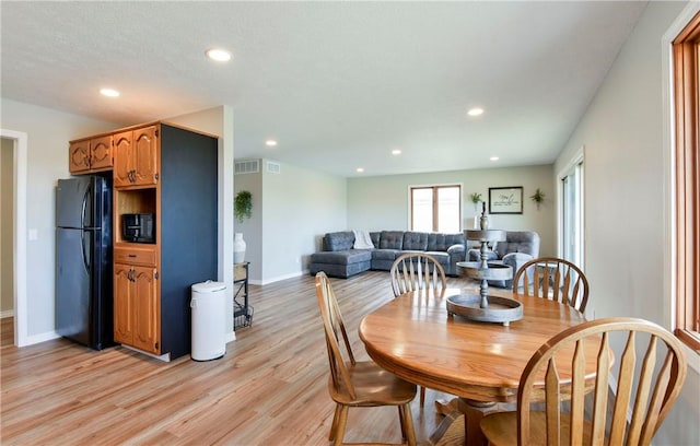 dining space featuring a textured ceiling and light hardwood / wood-style floors